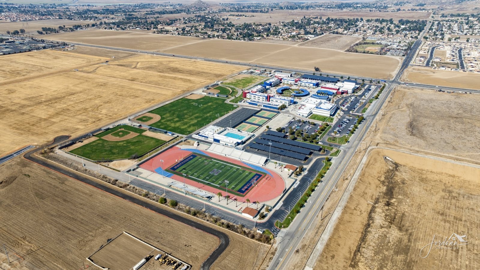 Aerial view of Heritage High School on Briggs Road in Menifee, with open farmland around the campus