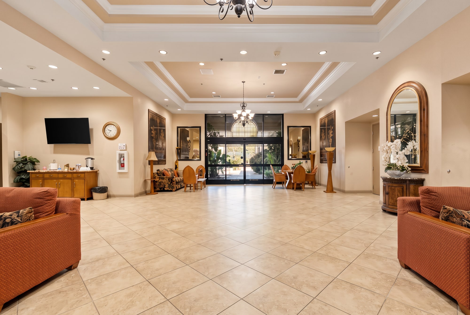 The lobby of The Oasis clubhouse in Menifee with a chandelier, tile floors and seating