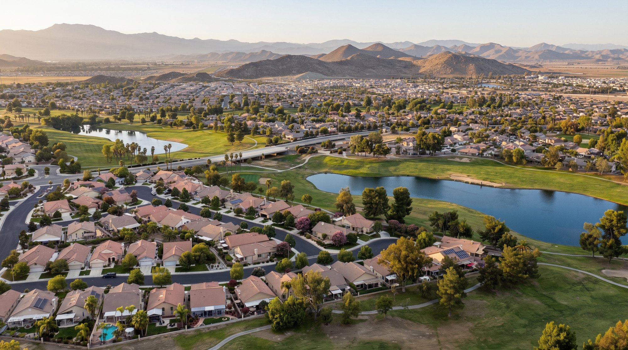 Aerial view of single story homes around the Menifee Lakes golf course and lakes at The Oasis in Menifee