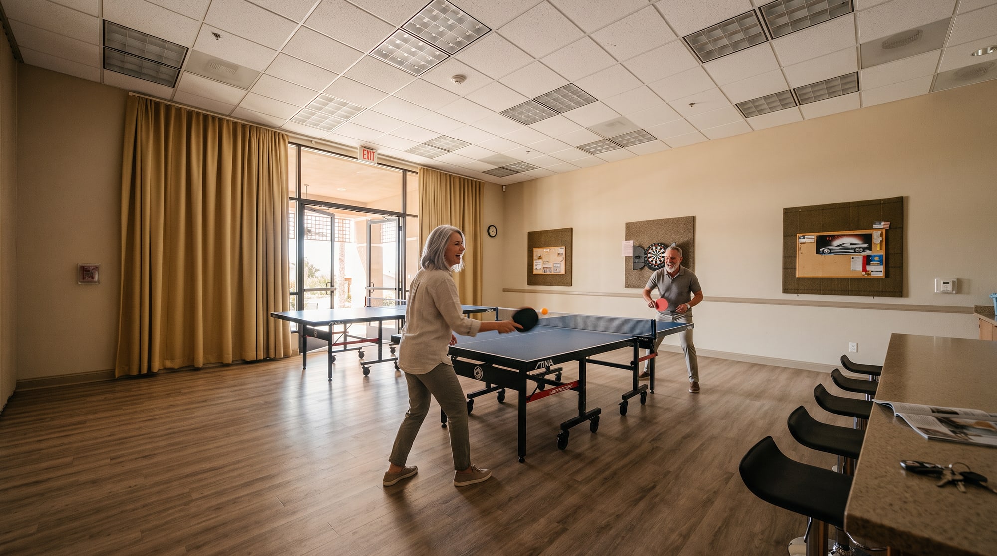 Two residents playing table tennis in the game room at The Oasis clubhouse in Menifee
